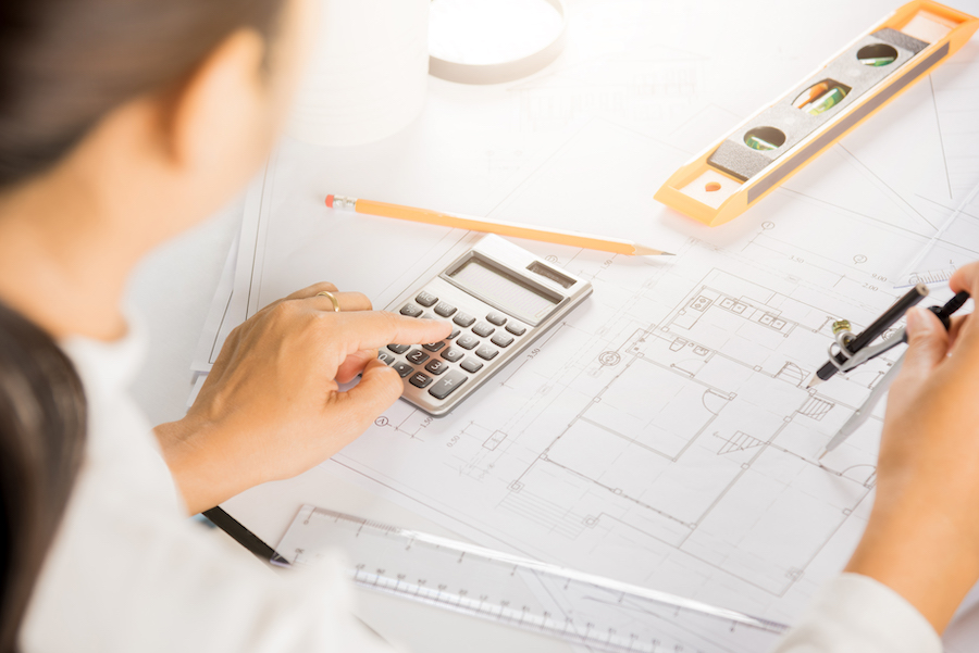 Architect drawing with divider compass on house plan blueprint paper